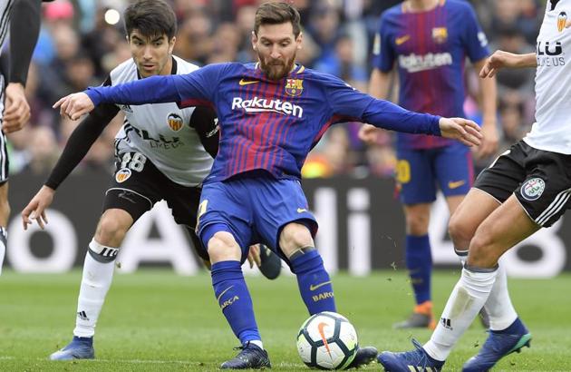 Barcelona's Argentinian forward Lionel Messi (R) shoots beside Valencia's Spanish midfielder Carlos Soler during the La Liga match between FC Barcelona and Valencia CF at the Camp Nou stadium in Barcelona on Saturday.(AFP)