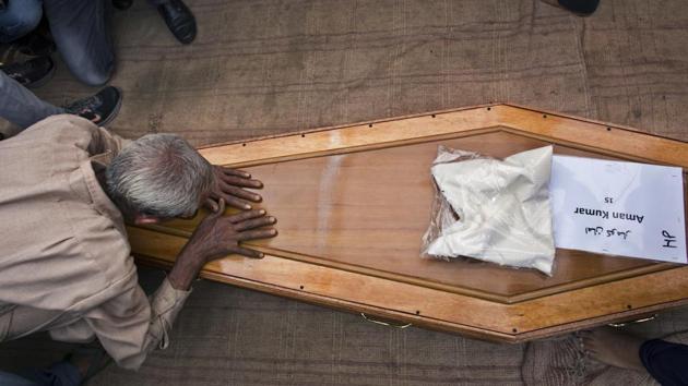 A relative pays his respects to the casket containing the remains of Aman Kumar, who was among the Indian construction workers killed by the Islamic State group in Iraq, in Dharmsala, India, Tuesday, April 3, 2018.(AP File Photo)