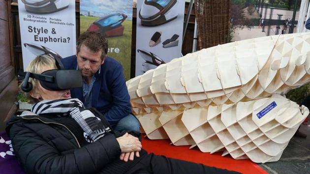 Dutch designer Alexander Bannink explains how the "Sarco" euthanasia pod works as a woman experiences sitting in the device by wearing virtual reality glasses.(AFP)