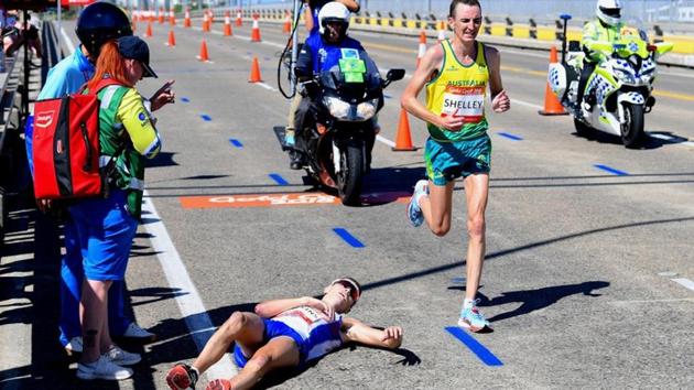 Scotland's Callum Hawkins lies on the ground as Australia's Michael Shelley runs past during the men's marathon final at the 2018 Commonwealth Games in Gold Coast on Sunday.(REUTERS)