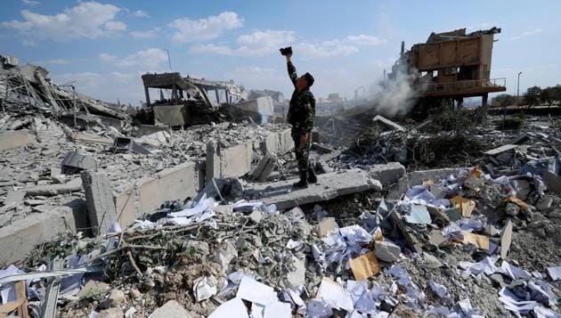 A Syrian soldier on Saturday films the damage of the Syrian Scientific Research Centre which was attacked by US, British and French military strikes to punish President Bashar Assad for suspected chemical attack against civilians.(AP)