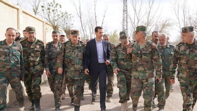 Syrian President Bashar al-Assad walks with Syrian army soldiers in eastern Ghouta, Syria, March 18, 2018.(REUTERS File Photo)