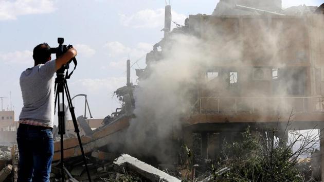 A journalist films the wreckage of a building described as part of the Scientific Studies and Research Centre compound in the Barzeh district, north of Damascus, on Saturday. (AFP Photo) A journalist films the wreckage of a building described as part of the Scientific Studies and Research Centre compound in the Barzeh district, north of Damascus, on Saturday. (AFP Photo)