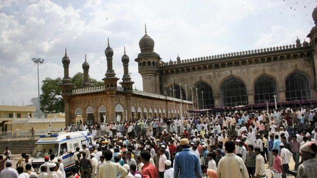 People look on as injured are being taken to the hospital in an ambulance from Mecca Masjid where a bomb blast occured during prayers.(PTI File Photo)