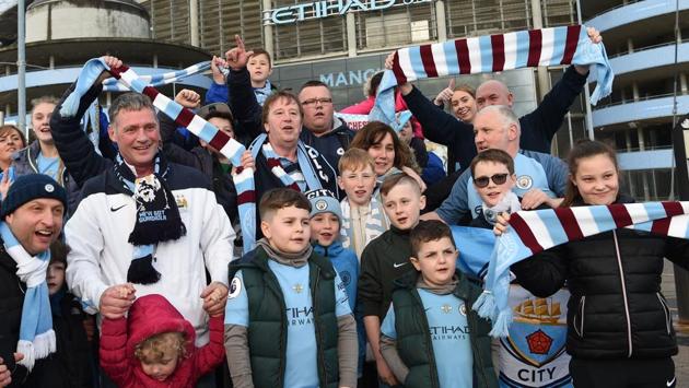 Manchester City supporters wave scarves and sing as they gather outside the Etihad Stadium in Manchester, England, on April 15, 2018, as news of City's Premier League title win spreads. (AFP) Manchester City supporters wave scarves and sing as they gather outside the Etihad Stadium in Manchester, England, on April 15, 2018, as news of City's Premier League title win spreads. (AFP)