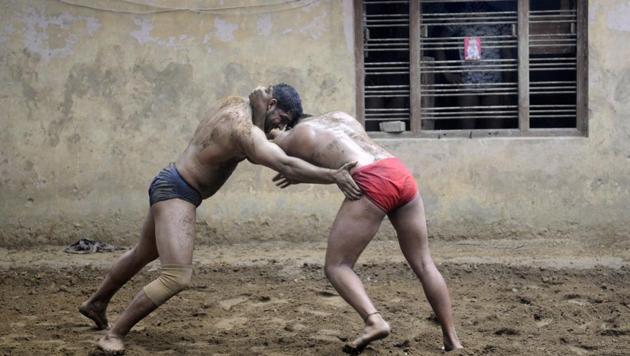 Over 100 amateur and professional wrestlers, including schoolchildren, train on a daily basis at Sukhbir Pahalwan’s akhara in Sarfabad village in Noida.(Sunil Ghosh/HT Photo)