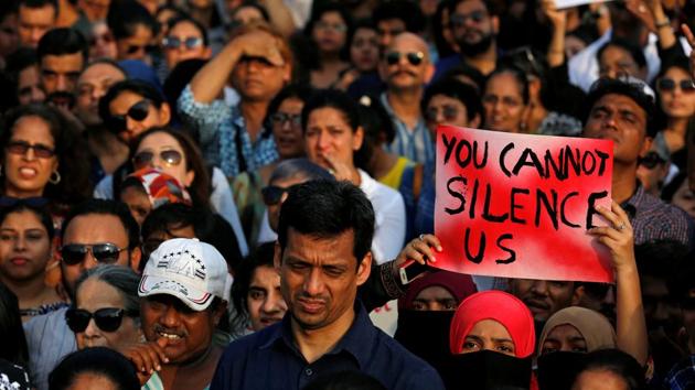 Women hold a placard during a protest against the rapes in Kathua and Unnao in Mumbai on Sunday.(Reuters Photo)