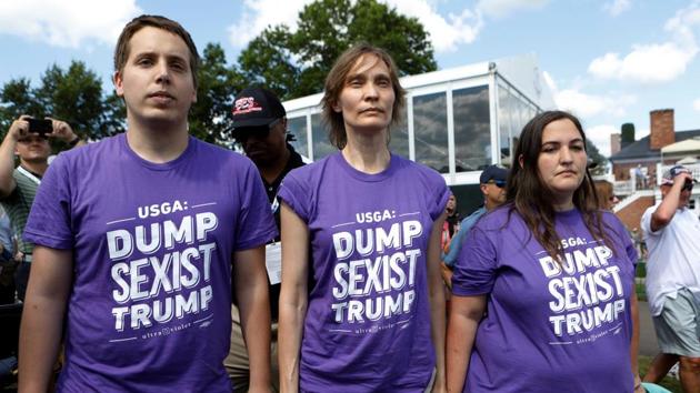 Protesters wearing anti-Trump shirts stand in front of US President Donald Trump's personal enclosure at the US Women's Open golf tournament at Trump National Golf Club, Bedminster, New Jersey (File Photo)(REUTERS)