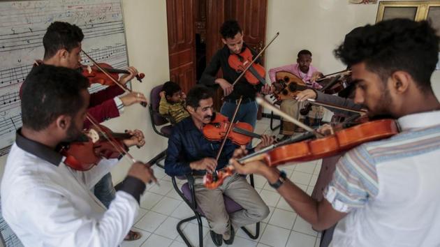 Abdullah El-Deb'y (C), instructs his students during a music class at the Cultural Centre. El-Deb’y offers free lessons to students eager to escape — at least psychologically — for a time the suffering caused by the war and is seeking to form a national orchestra amid the bombing comprised of young Yemenis. (Hani Mohammed / AP) Abdullah El-Deb'y (C), instructs his students during a music class at the Cultural Centre. El-Deb’y offers free lessons to students eager to escape — at least psychologically — for a time the suffering caused by the war and is seeking to form a national orchestra amid the bombing comprised of young Yemenis. (Hani Mohammed / AP)