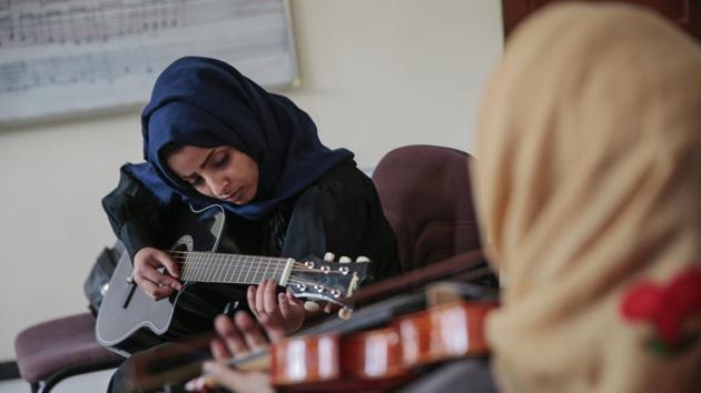 A student practicing playing the guitar is accompanied by a violinist. “I have a passion for music because it is the language of peace, especially considering the bad times we’re going through,” El-Deb’y said. (Hani Mohammed / AP) A student practicing playing the guitar is accompanied by a violinist. “I have a passion for music because it is the language of peace, especially considering the bad times we’re going through,” El-Deb’y said. (Hani Mohammed / AP)