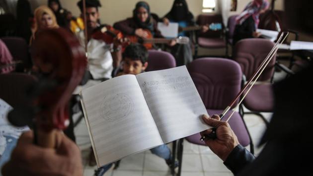 Abdullah El-Deb'y, holds out sheet music during one of his classes at the Cultural Centre in Sanaa. Students must worry about airstrikes when coming to class in a government building in the capital, Sanaa, and must sometimes seek shelter when fighter jets fly overhead. (Hani Mohammed / AP) Abdullah El-Deb'y, holds out sheet music during one of his classes at the Cultural Centre in Sanaa. Students must worry about airstrikes when coming to class in a government building in the capital, Sanaa, and must sometimes seek shelter when fighter jets fly overhead. (Hani Mohammed / AP)