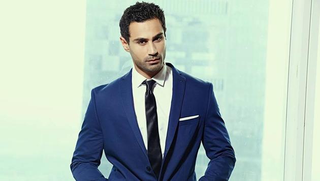 Fitted formals look dapper and make the right impact. Model Karan Oberoi is wearing a navy blue blazer teamed with white shirt and black tie.