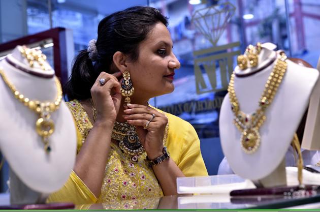 On the eve of Akshaya Tritiya, a woman tries a jewellery set at a store in Kalbhadevi on Tuesday. (Anshuman Poyrekar/HT Photo) On the eve of Akshaya Tritiya, a woman tries a jewellery set at a store in Kalbhadevi on Tuesday. (Anshuman Poyrekar/HT Photo)