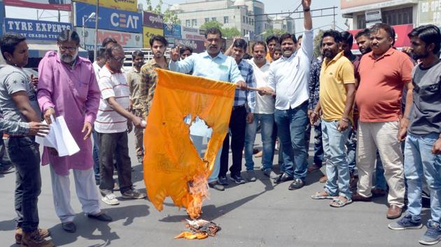 Members of Dalit community burn a saffron flag purportedly symbolising the “upper caste” Hindu right wing — Shiv Sena factions and the Rashtriya Swayamsevak Sangh — at Shastri Chowk on Tuesday.(HT Photo)