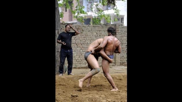Surendra Singh Yadav (L), an army veteran, trains wrestlers in the loose soil mixed with henna, mustard oil and turmeric in Sarfabad. Sukhbir Singh (not pictured), an army veteran and former wrestler who also runs an ‘akhara’ in the village believes once wrestlers are past their prime, it is the duty of society to ensure they don’t lose dignity in search of livelihood. (Sunil Ghosh / HT Photo) Surendra Singh Yadav (L), an army veteran, trains wrestlers in the loose soil mixed with henna, mustard oil and turmeric in Sarfabad. Sukhbir Singh (not pictured), an army veteran and former wrestler who also runs an ‘akhara’ in the village believes once wrestlers are past their prime, it is the duty of society to ensure they don’t lose dignity in search of livelihood. (Sunil Ghosh / HT Photo)