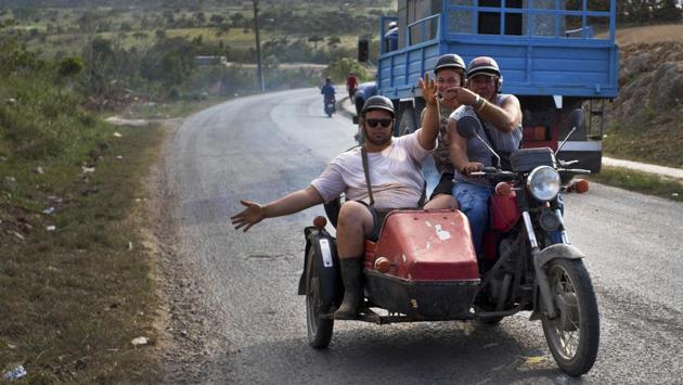 Motorcycle taxi driver Ricardo Medina, 60, transports vegetable vendor Rigoberto Herrera Mendez (L), and coconut vendor Osvaldo Ochoa in Campo Florido. The three men expressed hope that new leadership will improve things, saying the country cannot move backwards. “We survive life with our work,” Medina said. (Ramon Espinosa / AP) Motorcycle taxi driver Ricardo Medina, 60, transports vegetable vendor Rigoberto Herrera Mendez (L), and coconut vendor Osvaldo Ochoa in Campo Florido. The three men expressed hope that new leadership will improve things, saying the country cannot move backwards. “We survive life with our work,” Medina said. (Ramon Espinosa / AP)
