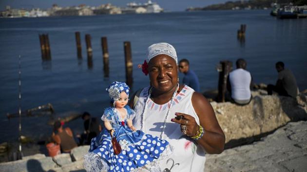 Santera Lourdes Nusa, 57, poses with her doll representing the Yoruba sea goddess “Yemaya” in Regla. Lourdes reads people’s futures. “The world is subject to change. Our country has always adopted a policy of improving relations with the entire world,” she said, adding Donald Trump’s position will not change Cuba’s position to open relations with the US. (Ramon Espinosa / AP) Santera Lourdes Nusa, 57, poses with her doll representing the Yoruba sea goddess “Yemaya” in Regla. Lourdes reads people’s futures. “The world is subject to change. Our country has always adopted a policy of improving relations with the entire world,” she said, adding Donald Trump’s position will not change Cuba’s position to open relations with the US. (Ramon Espinosa / AP)