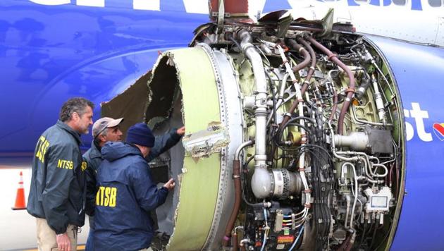 National Transportation Safety Board investigators examine damage to the engine of the Southwest Airlines plane that made an emergency landing at Philadelphia International Airport in Philadelphia on Tuesday, April 17, 2018.(AP Photo)