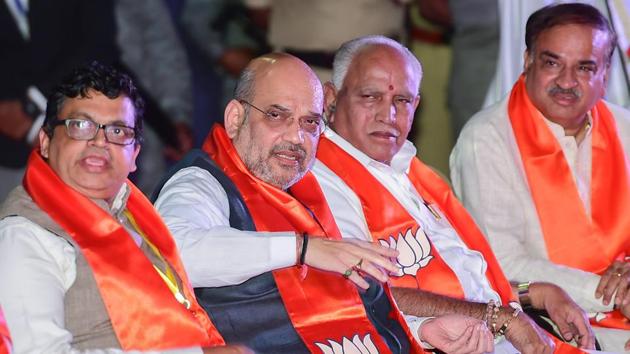 BJP National President Amit Shah speaks as State President B S Yeddyurappa and Union Minister Ananth Kumar at an event in Bengaluru on Thursday.(PTI)