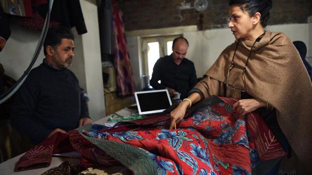 Owner Zolaykha Sherzad (R) shows a traditional chapan coat to her employees. Launched in 2006, “Zarif” -- “precious” in Persian -- commissions traditional cotton and silk from artisanal weavers, and employs more than two dozen people to tailor and design the fabrics into handcrafted, embroidered clothing. But with cheaper imports saturating the market, they are struggling to keep afloat. (Wakil Kohsar / AFP) Owner Zolaykha Sherzad (R) shows a traditional chapan coat to her employees. Launched in 2006, “Zarif” -- “precious” in Persian -- commissions traditional cotton and silk from artisanal weavers, and employs more than two dozen people to tailor and design the fabrics into handcrafted, embroidered clothing. But with cheaper imports saturating the market, they are struggling to keep afloat. (Wakil Kohsar / AFP)