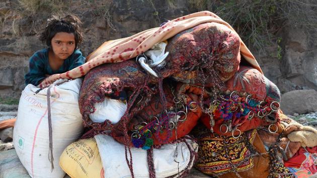 A girl is seen with her family belongings at her temporary camp near Udhampur. In Kathua case, according to police a group of people tortured and killed the girl in a bid to scare the Bakarwals out of the district definitively. This case has not only frightened the Bakarwals but also created a national storm of controversy. (Sajjad Hussain / AFP) A girl is seen with her family belongings at her temporary camp near Udhampur. In Kathua case, according to police a group of people tortured and killed the girl in a bid to scare the Bakarwals out of the district definitively. This case has not only frightened the Bakarwals but also created a national storm of controversy. (Sajjad Hussain / AFP)