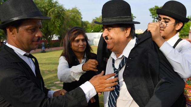 Talin Mavani helps his grandfather dress up during the Chaplin birthday parade organised by Charlie Circle. Crumpled suits and ties badly knotted were the costume of choice for the impersonators during the two-hour-long procession. (Indranil Mukherjee / AFP) Talin Mavani helps his grandfather dress up during the Chaplin birthday parade organised by Charlie Circle. Crumpled suits and ties badly knotted were the costume of choice for the impersonators during the two-hour-long procession. (Indranil Mukherjee / AFP)