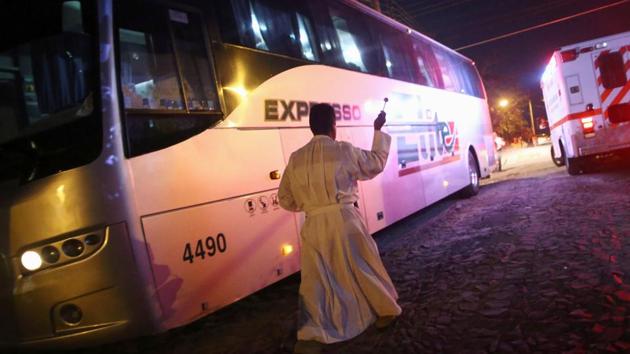 A priest blesses a migrants’ bus travelling to Mazatlan, as part of their new travel route. Since peaking at around 1,500 people, the so-called migrant “caravan” has dwindled under pressure from Trump and Mexican migration authorities, who vowed to separate those migrants with a right to stay in Mexico from those who did not. (Edgard Garrido / REUTERS) A priest blesses a migrants’ bus travelling to Mazatlan, as part of their new travel route. Since peaking at around 1,500 people, the so-called migrant “caravan” has dwindled under pressure from Trump and Mexican migration authorities, who vowed to separate those migrants with a right to stay in Mexico from those who did not. (Edgard Garrido / REUTERS)