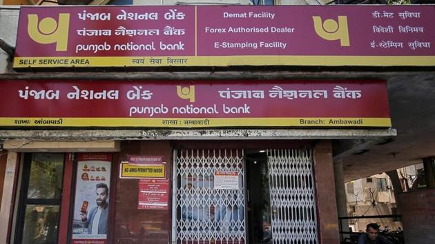 A man reads a newspaper outside a branch of Punjab National Bank in Ahmedabad.(REUTERS)