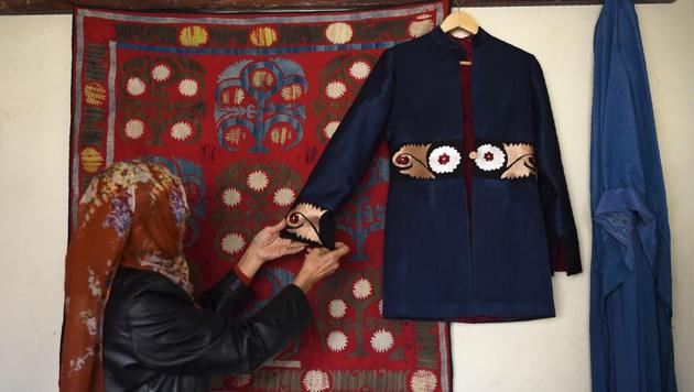 An Afghan tailor hangs an embroidered coat on the wall at Zarif Design House in Kabul. As mass produced nylon and polyester burkas made in China flood Afghanistan feeding consumer appetite for affordable, mass-produced fabric, this small but determined fashion house is fighting to preserve the traditional textiles once integral to Afghan culture. (Wakil Kohsar / AFP) An Afghan tailor hangs an embroidered coat on the wall at Zarif Design House in Kabul. As mass produced nylon and polyester burkas made in China flood Afghanistan feeding consumer appetite for affordable, mass-produced fabric, this small but determined fashion house is fighting to preserve the traditional textiles once integral to Afghan culture. (Wakil Kohsar / AFP)