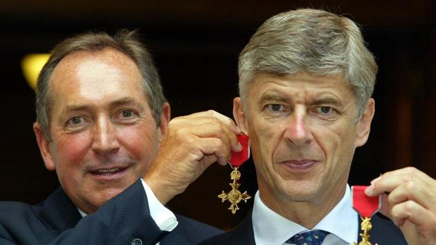Gerard Houllier (L) holds his OBE medal as an earring on long-term friend and Arsene Wenger. (AFP) 