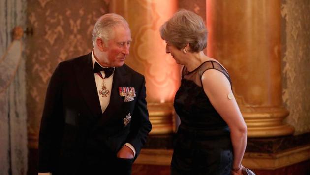 Britain's Prince Charles speaks to Prime Minister Theresa May before taking part in a receiving line at the Queen's Dinner for the Commonwealth Heads of Government Meeting (CHOGM) at Buckingham Palace in London, on April 19, 2018.(Reuters)