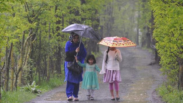 A woman along with her children holds umbrella as it rains in Srinagar, India. Gulmarg and other areas in the higher reaches of Kashmir received fresh snowfall today, while the plains in the valley were lashed by rains. (Waseem Andrabi / HT Photo) A woman along with her children holds umbrella as it rains in Srinagar, India. Gulmarg and other areas in the higher reaches of Kashmir received fresh snowfall today, while the plains in the valley were lashed by rains. (Waseem Andrabi / HT Photo)