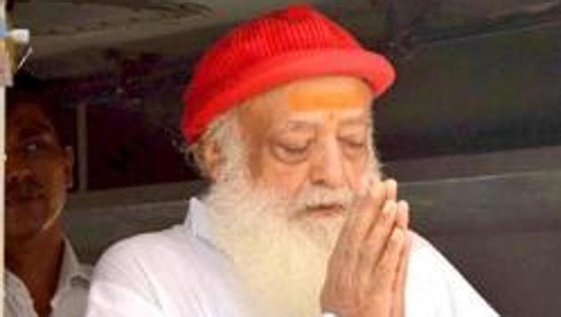 Asaram Bapu greets his supporters as he arrives for a hearing at a court in Jodhpur, Rajasthan.(Ramji Vyas/HT Photo)
