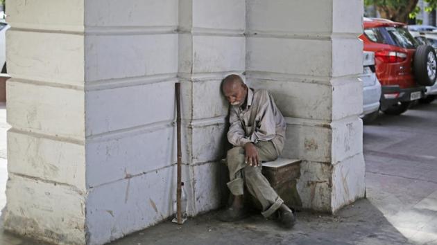 A homeless man props himself against a wall, taking a nap in New Delhi on April 18, 2018. (Altaf Qadri / AP) A homeless man props himself against a wall, taking a nap in New Delhi on April 18, 2018. (Altaf Qadri / AP)