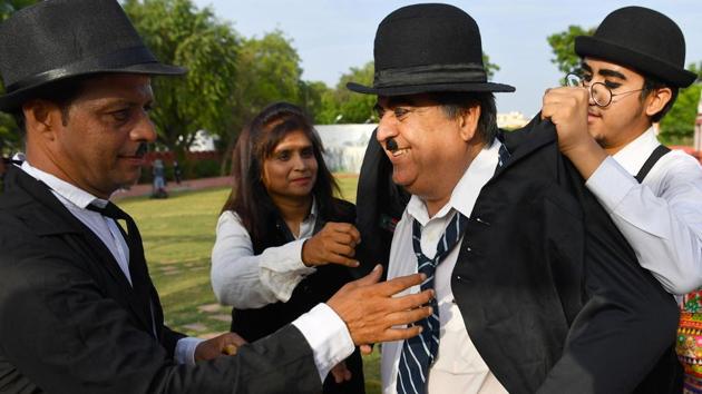 Talin Mavani (R), a Charlie Chaplin impersonator helps his grandfather Ashok Aswani, founder of the Charlie Circle fan club, dress up during an event commemorating the legendary actor's 129th birthday in Adipur, Gujarat on April 16, 2018. (Indranil Mukherjee / AFP) Talin Mavani (R), a Charlie Chaplin impersonator helps his grandfather Ashok Aswani, founder of the Charlie Circle fan club, dress up during an event commemorating the legendary actor's 129th birthday in Adipur, Gujarat on April 16, 2018. (Indranil Mukherjee / AFP)