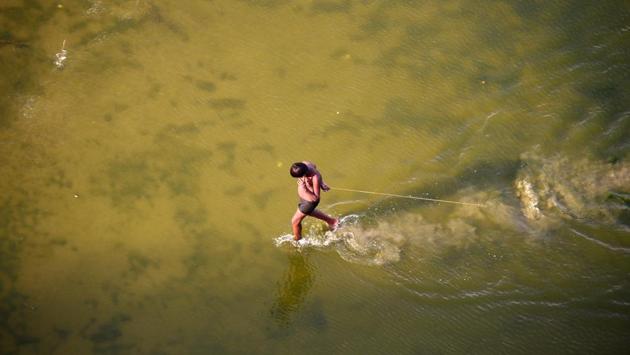 An boy sifts for coins thrown by Hindu devotees in the river Ganga as offerings in Allahabad on April 16, 2018. (Sanjay Kanojia / AFP) An boy sifts for coins thrown by Hindu devotees in the river Ganga as offerings in Allahabad on April 16, 2018. (Sanjay Kanojia / AFP)