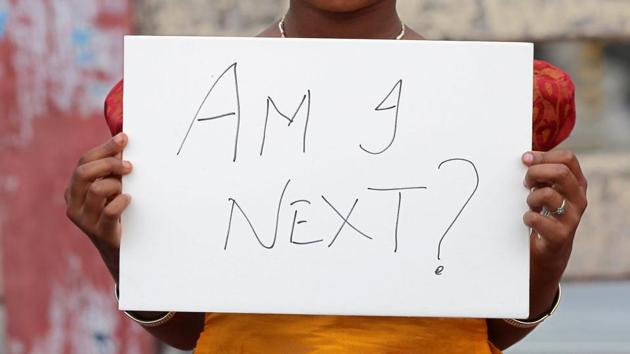 A child holds a placard during a protest against rape, in Kochi on April 15, 2018.(Reuters)