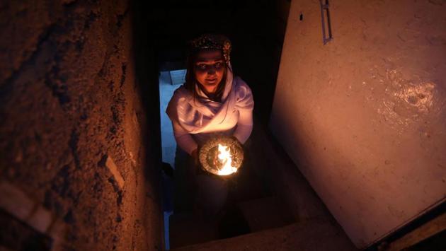 An Iraqi Yazidi carries a candle inside Lalish temple during a ceremony to celebrate the Yazidi New Year in a valley near Dohuk, Iraq on April 17, 2018. (Safin Hamed / AFP)
