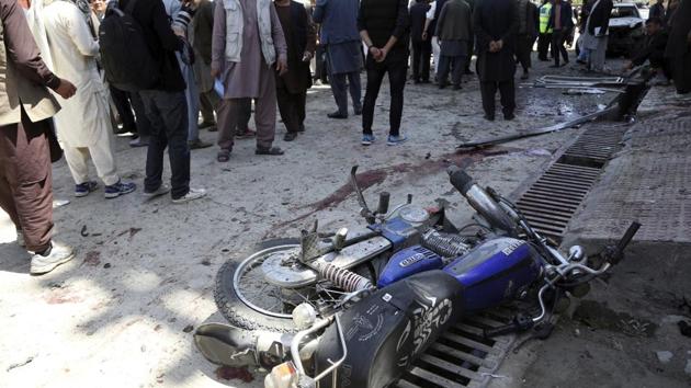 People gather outside a voter registration centre which was attacked by a suicide bomber in Kabul, Afghanistan, on April 22, 2018.(AP)