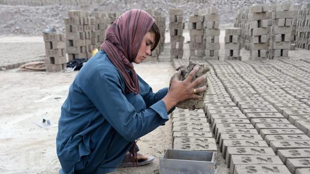 Afghan female labourer Sitara Wafadar, 18, who dresses as a male in order to support her family, working at a brick factory in Sultanpur village in Surkh Rod district, in Nangarhar province.(AFP)
