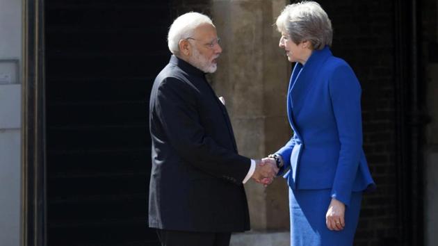British PM Theresa May greets Prime Minister Narendra Modi at the official welcome ceremony for the Commonwealth Heads of Government Meeting in London.(AP)
