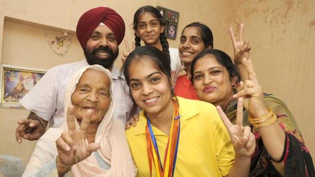 PSEB Class 12 Patiala district topper Harman Deep Kaur of celebrates with her family at Shekhupura village in Patiala on Monday. (Bharat Bhushan /HT)