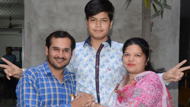 Vivek Rajput, who topped the PSEB Class 12 exams with 97.56 percent (Non-Medical stream), celebrates with his parents. (Gurpreet Singh/HT)