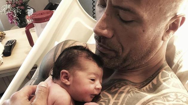 Dwanye ‘The Rock’ Johnson cradles his daughter after she was born on Monday.(Instagram)