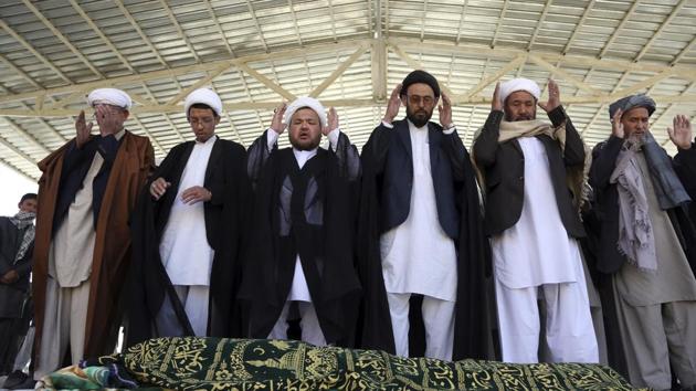 Afghan people offer funeral prayers behind the body of a civilian killed in Sunday's deadly suicide attack at a voter registration center, in Kabul, Afghanistan, on Monday.(AP Photo)