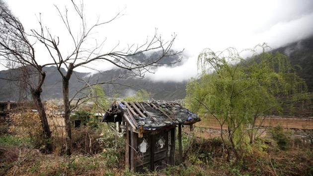 Only the door stands among weeds from villager Wang Guocheng’s dwelling. In some houses still standing, now part of an open air memorial to the dead, wedding photos hang on the wall. Chen Mingyou, 73, survived the quake but his daughter and son-in-law died. A new home stands nearby, but Chen prefers to stay in his old house which was repaired to meet new safety standards. (Jason Lee / REUTERS)