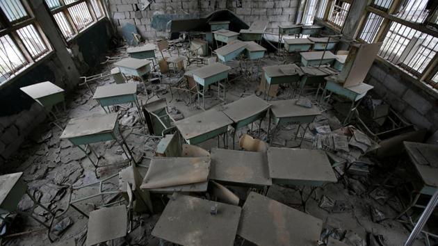 Desks stand in the classroom of Beichuan Vocational Education Centre. Damaged school classrooms remain a mess, with books on the desks turning black with rot. Signs in Chinese, English, Japanese, Korean and French urge visitors to be careful where they tread to let the dead rest in peace. (Jason Lee / REUTERS)