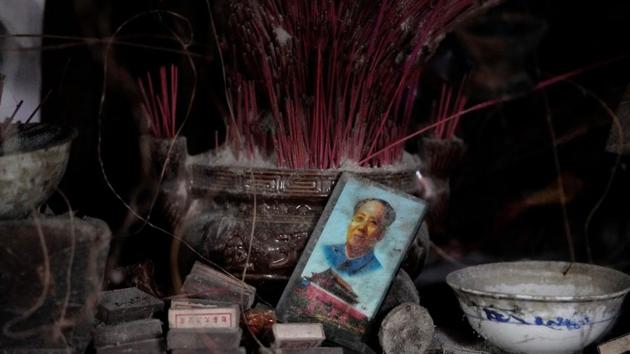 A card featuring the late Chinese Chairman Mao Zedong and Tiananmen Gate is seen next to a shrine in tan old destroyed home. Last August, a 7.0-magnitude quake in a mountainous part of Sichuan popular with tourists killed 20 and injured around 500. (Jason Lee / REUTERS)