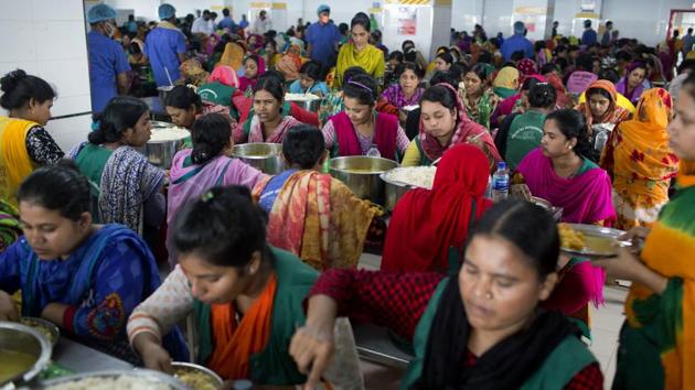Workers eat lunch at the Snowtex garment factory in Dhamrai, Bangladesh. The factory, a few kilometers from where Rana Plaza stood, has about 8,000 workers on its five floors spread over 52,000 square feet each. It has wide stairwells, emergency exits, fire safety equipment, sprinklers and first-aid equipment on hand. Workers have been trained in fire safety and rescue techniques and regular fire drills are performed. (A.M. Ahad / AP)