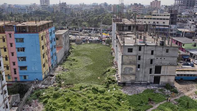 Overgrown bushes cover the area where the Rana Plaza once stood. A recent study conducted by the Center for Business and Human Rights at New York University found that textile factory workers at about 3,000 of the country’s 7,000 factories are still exposed to life-threatening risks, ranging from a lack of fire safety equipment to serious structural flaws. (A.M. Ahad / AP)